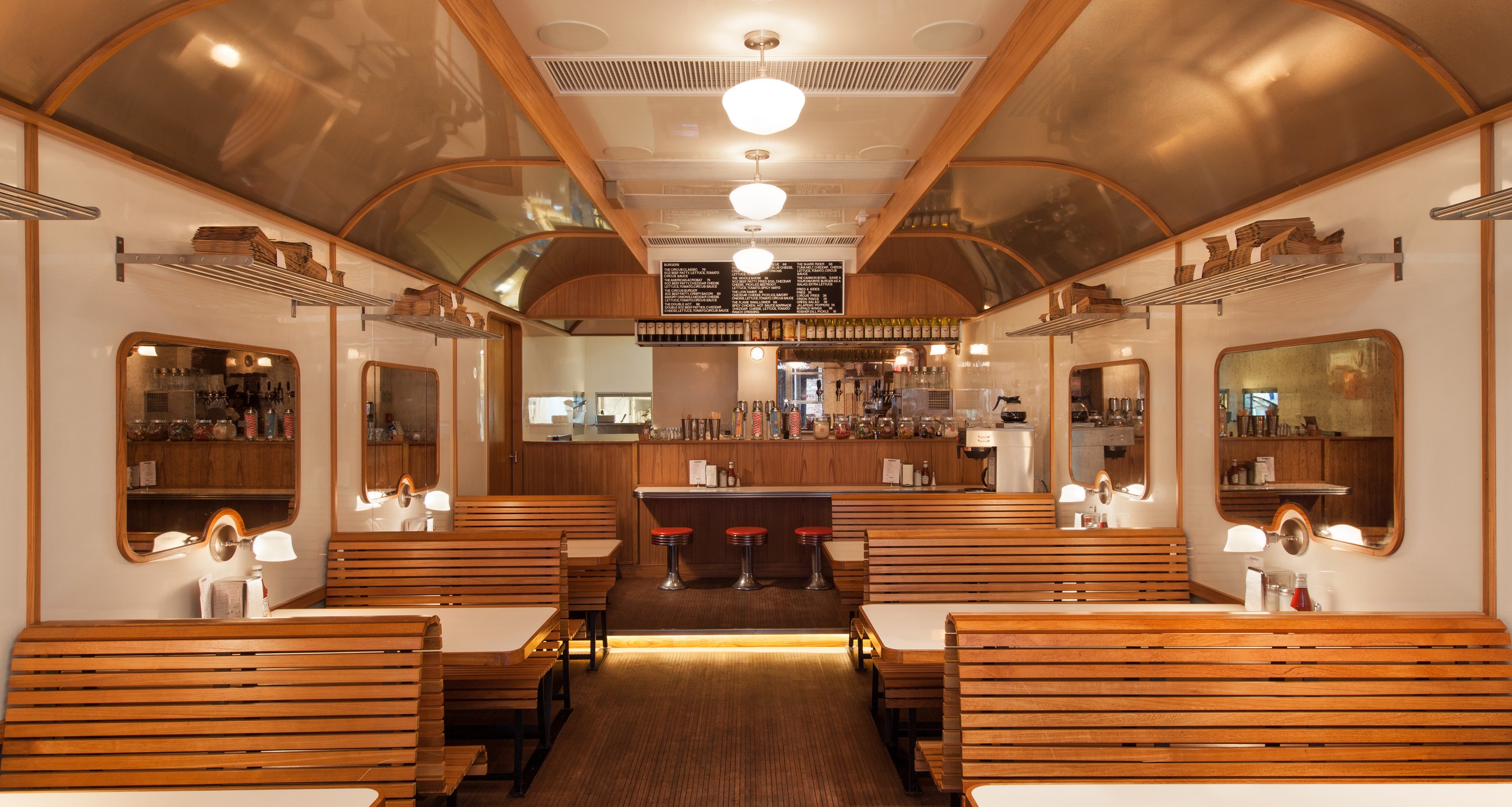 Interior of a diner styled like a train car, with wooden booths and a counter.