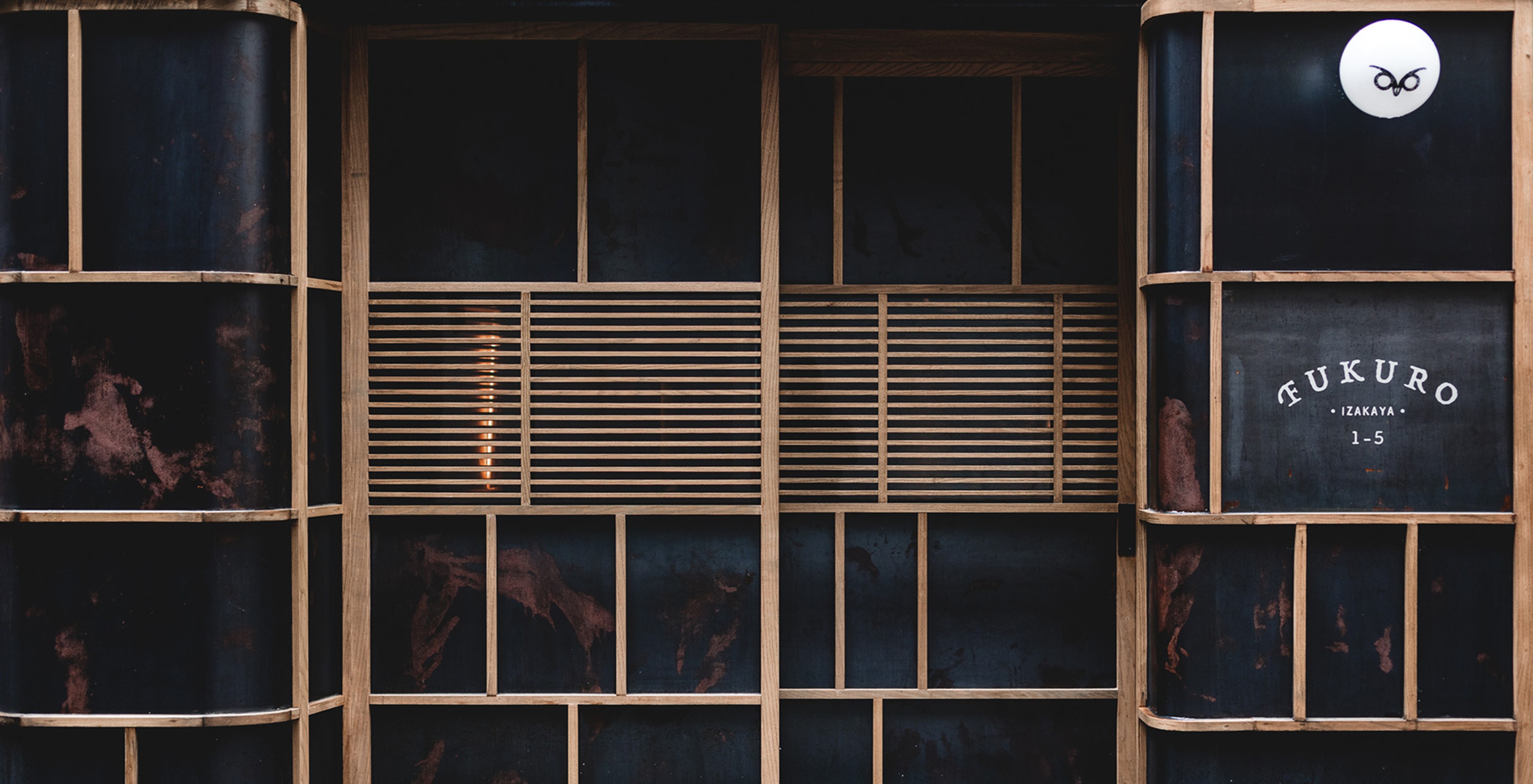 Dark storefront with light wooden grid, an owl logo, "FUKURO" text, and horizontal slatted windows.