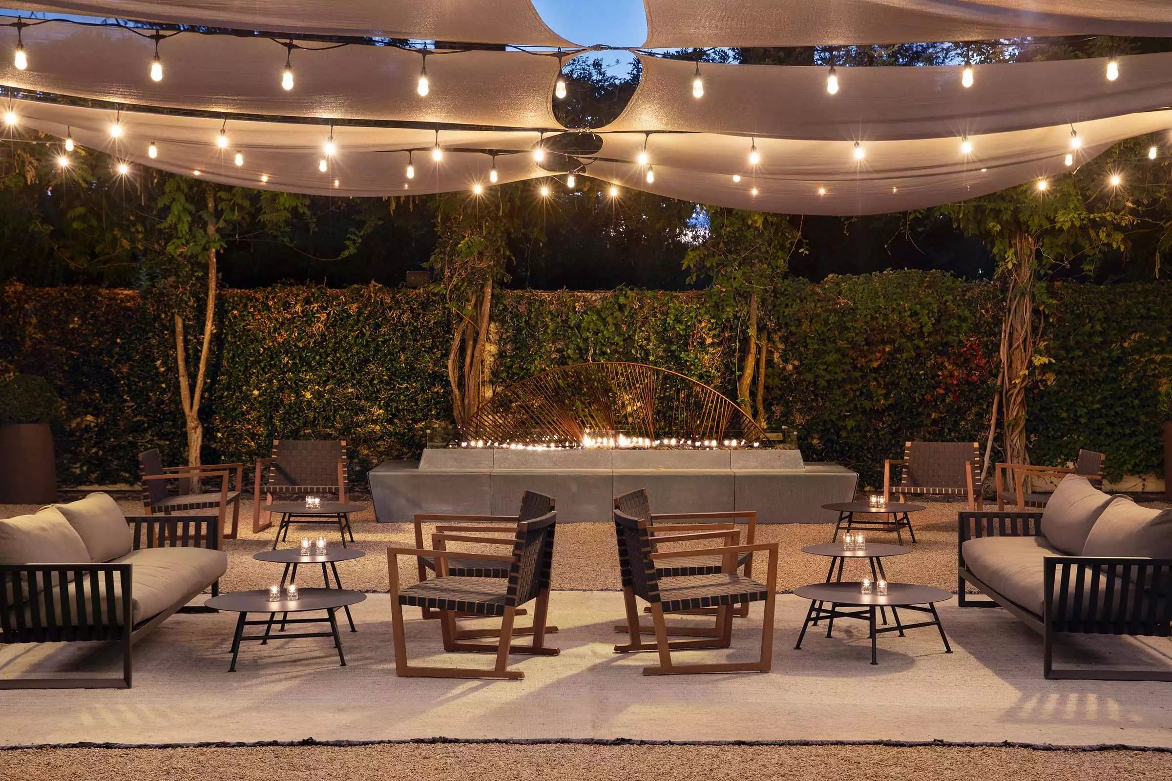The hotel's garden patio glowing with string lights at dusk