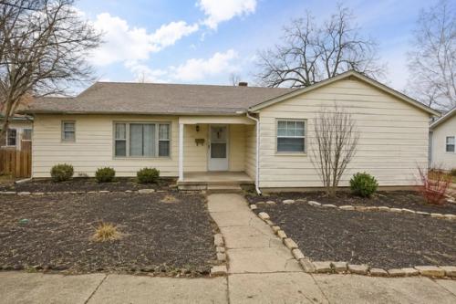 A single-story ranch home with a bare gravel yard, sitting empty