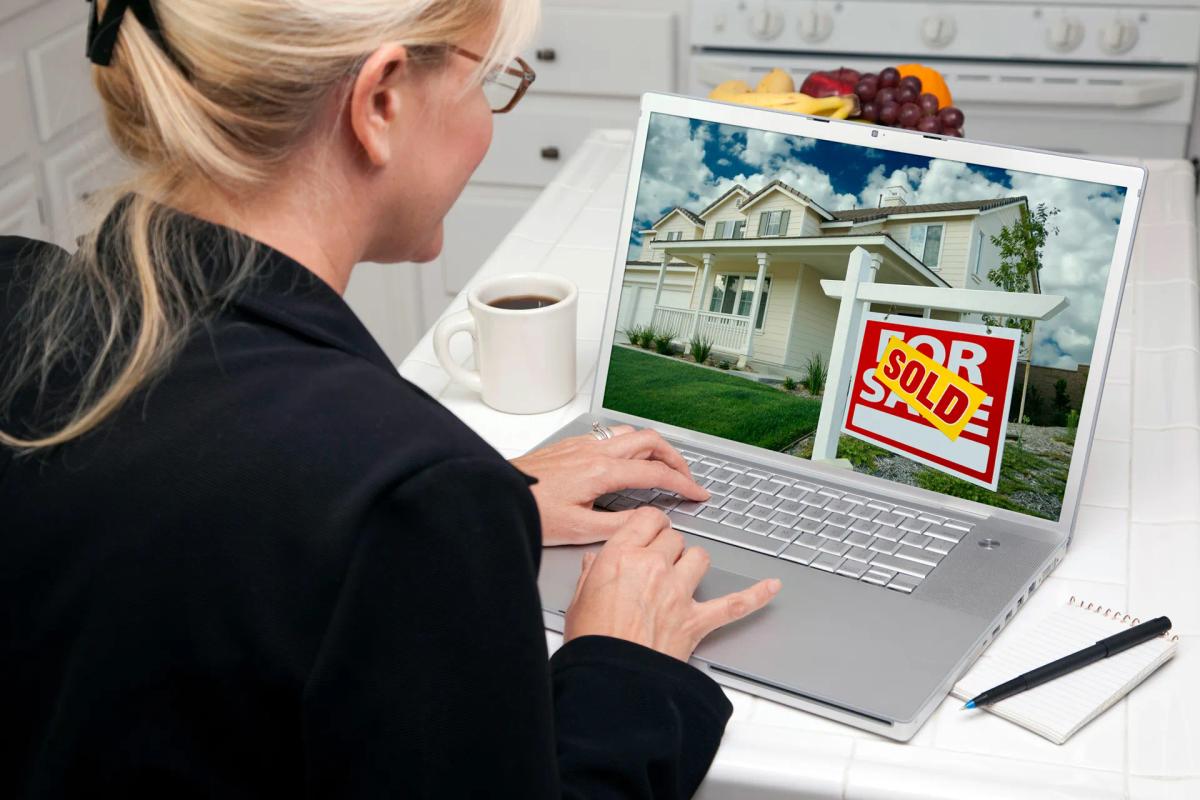 Woman In Kitchen Using Laptop for Real Estate