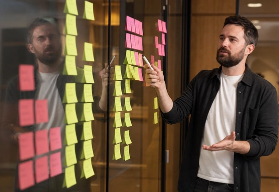 Consultant and founder reviewing a site map and content model on paper beside a laptop