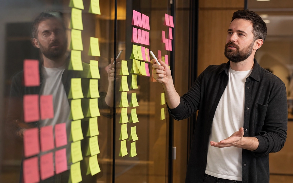 Consultant and founder reviewing a site map and content model on paper beside a laptop