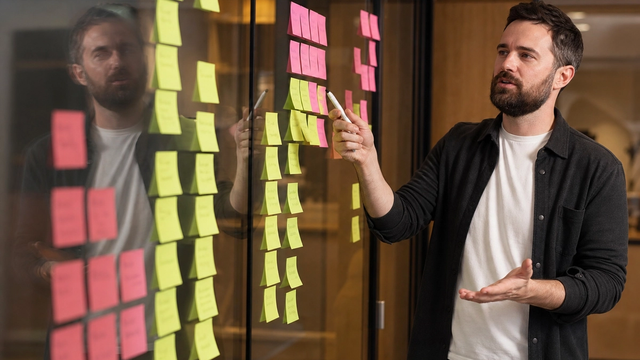 Consultant and founder reviewing a site map and content model on paper beside a laptop