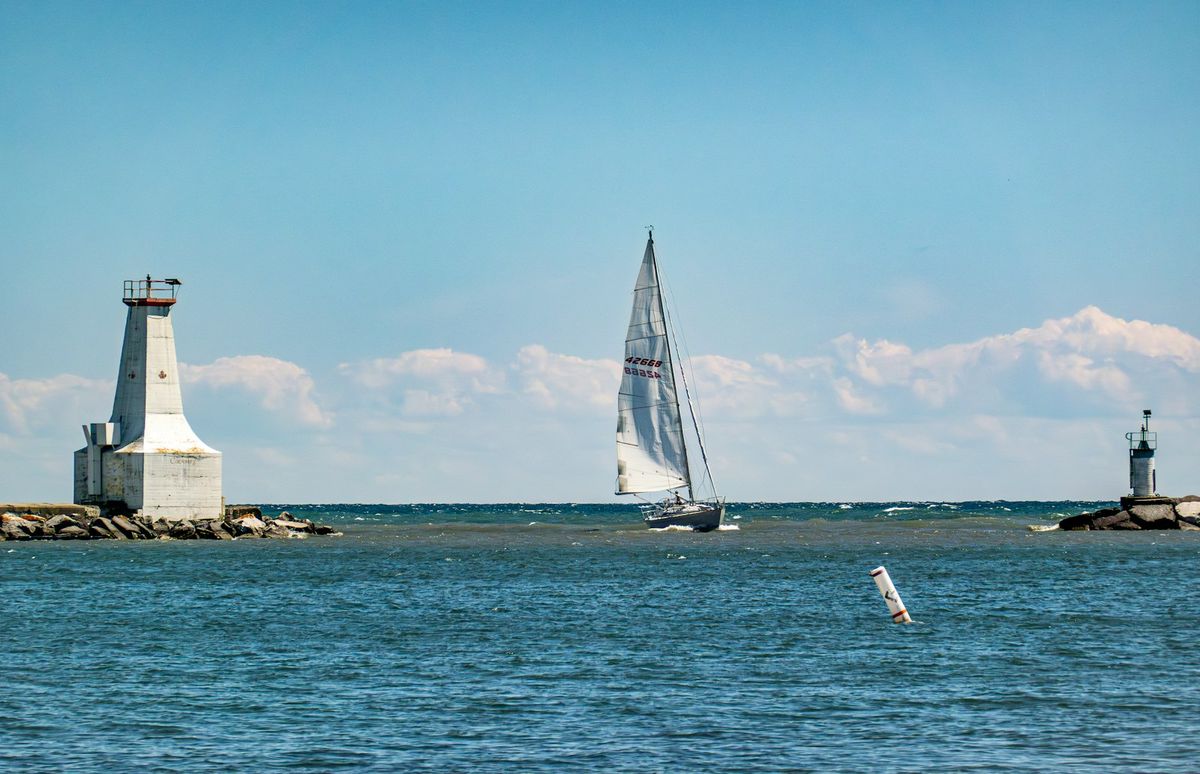 Sailboat near lighthouse on New England coast