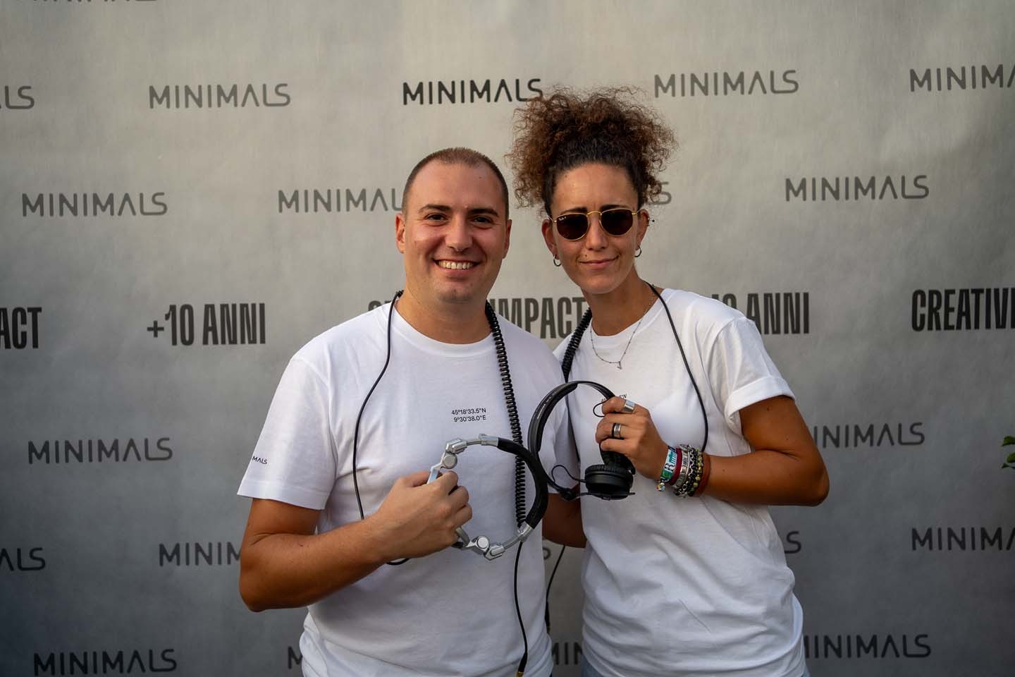 Scatto celebrativo davanti al pannello dell'agenzia per l'evento Minimals 10 Anni