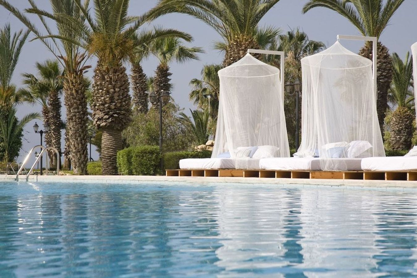 På Sentido Sandy Beach i Larnaca, Cypern, kan du sætte dig ned i en cabana ved poolen og nyde det smukke vejr.