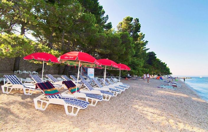 Stranden med solsenger ved Hotel Villa Bacchus