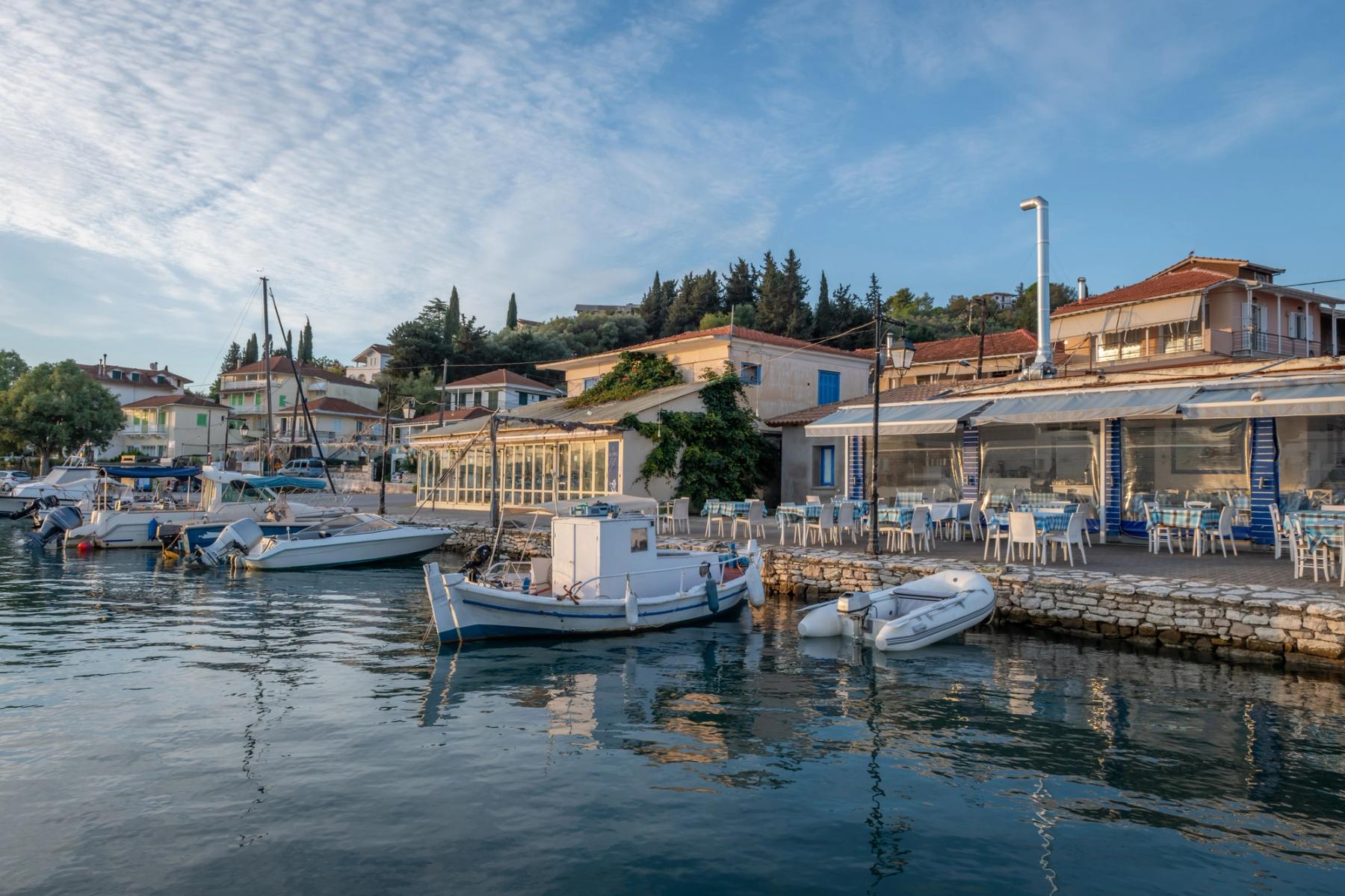 Utsikt över den idylliska fiskebyn Ligia med små båtar och tavernor på Lefkas i Grekland