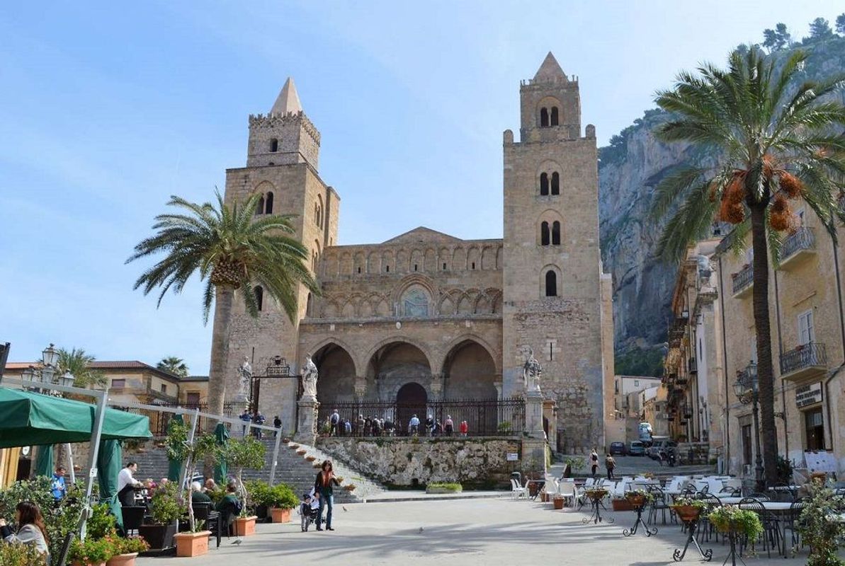 Mysiga kaféer på torget framför kyrkan i Cefalù på Sicilien i Italien