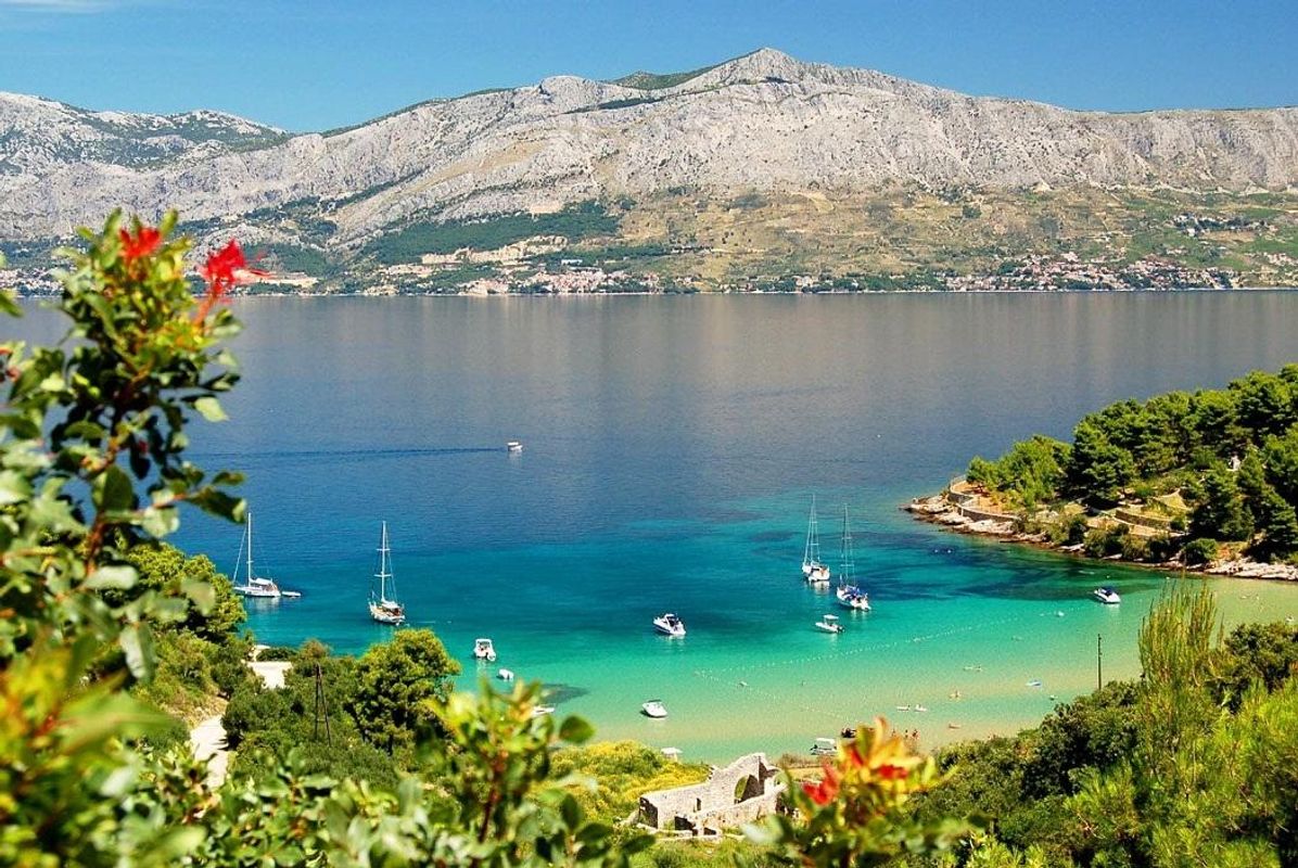 Udsigt over havet med sejlbåde og bjerge i baggrunden på øen Brac i Kroatien