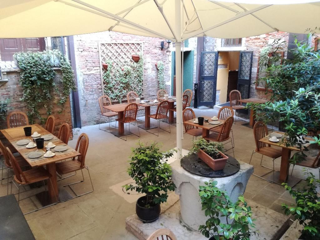 På Locanda La Corte kan du nyde en morgenmad på den indre gård inden du beger dig ud for at optage Venedig.