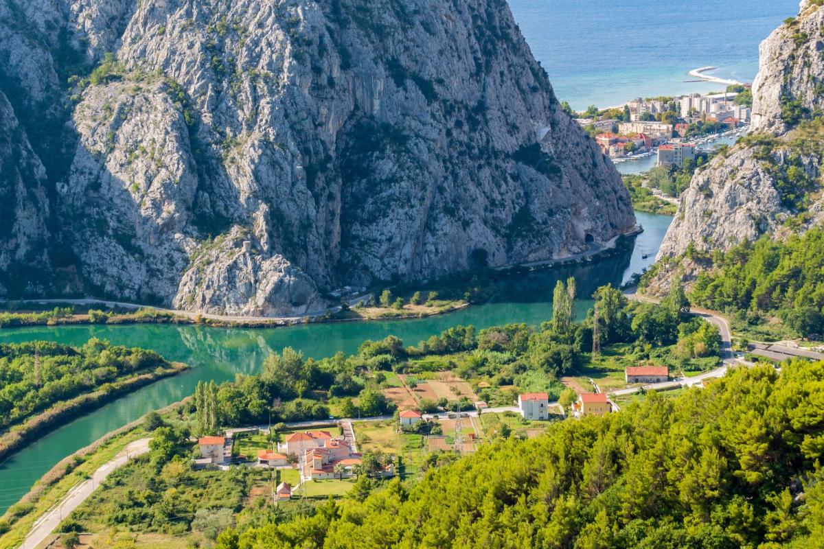 Cetina elva i Dalmatia snor seg gjennom det grønne landskapet med høye fjell og havet i horisonten
