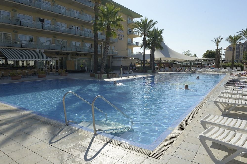 Hotel med pool, palmer og solstole