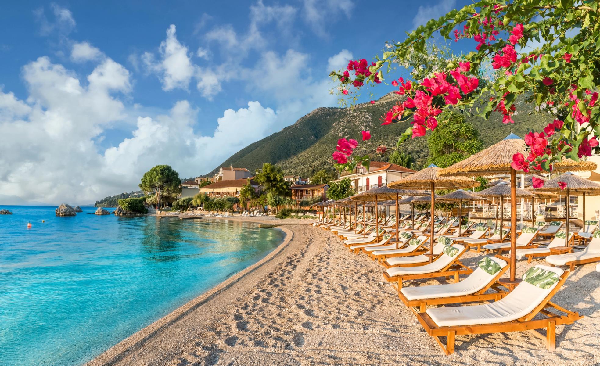 Utsikt över den härliga sandstranden med solstolar och parasoller i Nikiana, Lefkas, Grekland