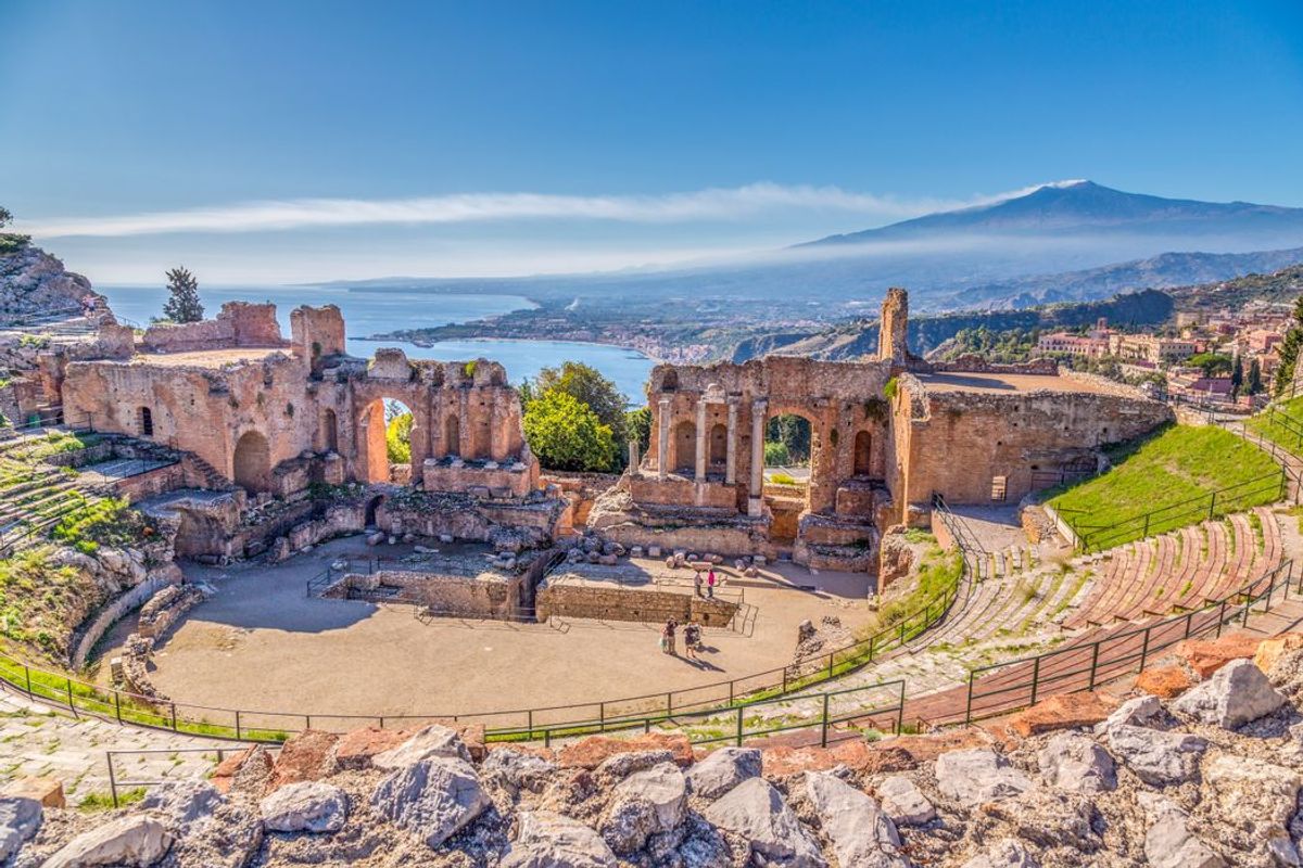 Udsigt over det antikke græsk-romerske teater i Taormina med vulkanen Etna i horisonten.