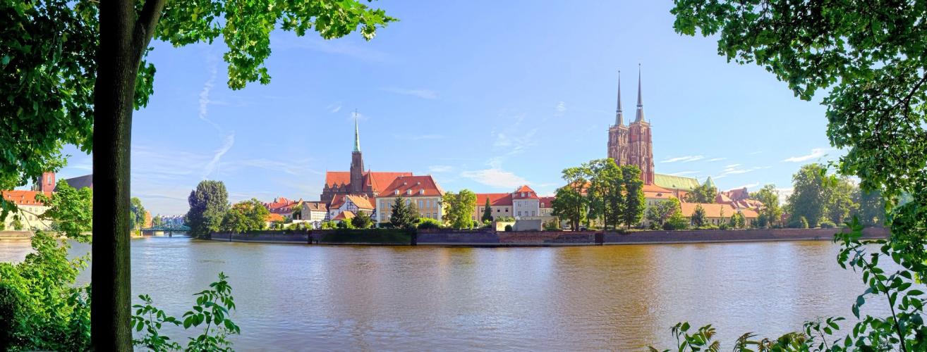 Billedet viser den del af den gamle bydel i Wroclaw, der ligger tættest på floden Oder. Tættest på billedet er floden, og længst inde i billedet ses de ældre bygninger i den gamle bydel med katedralens tårne lidt til højre i billedet.