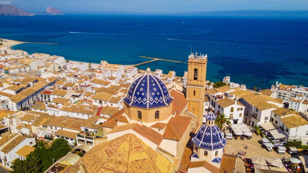 Luftfoto af Altea med kirken og hustagene i den gamle bydel og havet i baggrunden