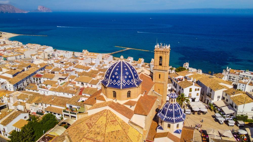 Luftfoto av Altea med kirken og hustakene i gamlebyen og havet i bakgrunnen