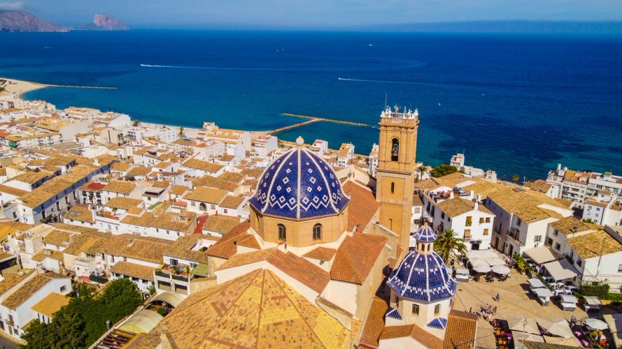 Luftfoto av Altea med kirken og hustakene i gamlebyen og havet i bakgrunnen