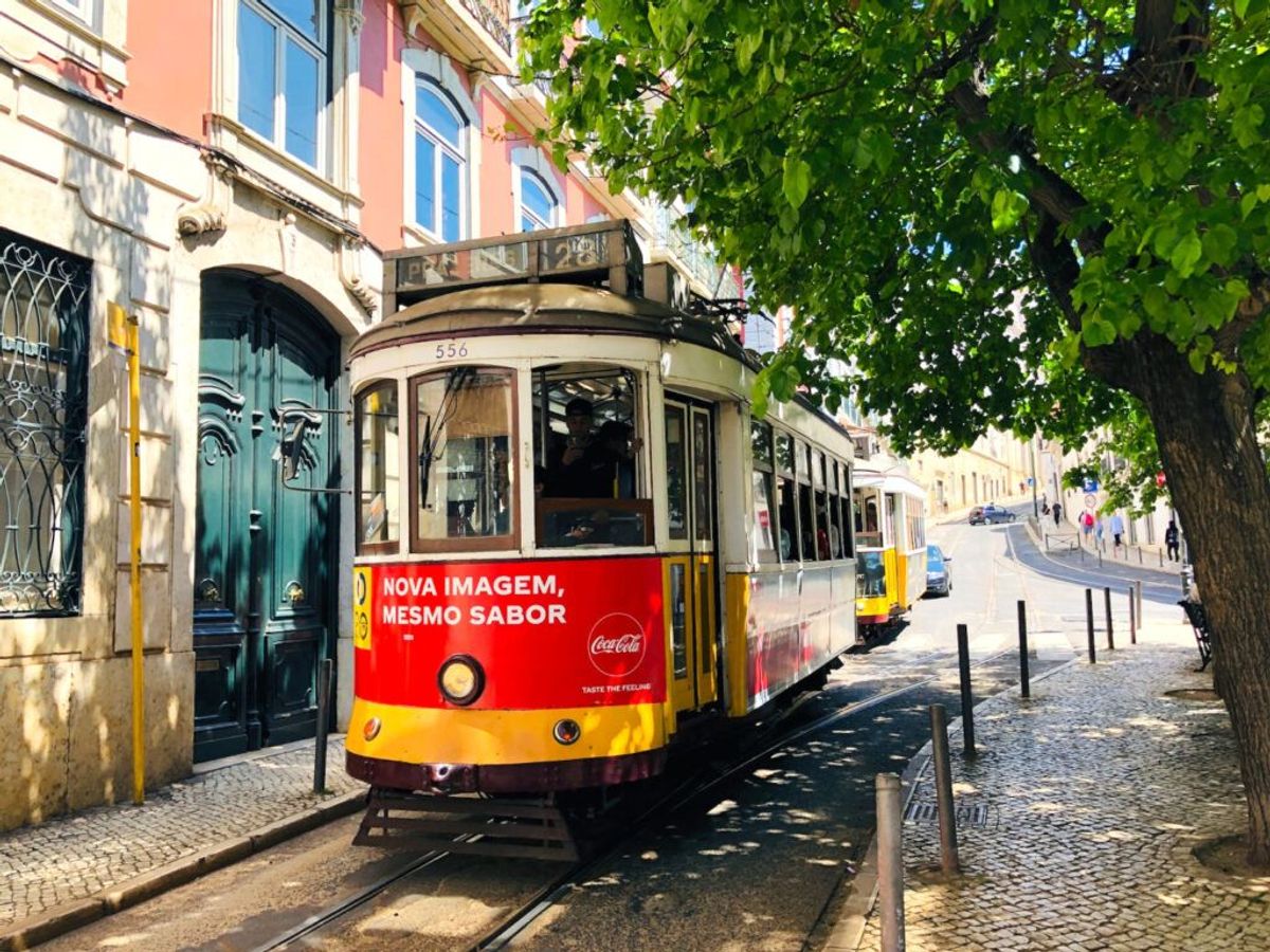 Bildet viser den gule, karakteristiske trikk 28 som tar deg til Alfama, den eldste bydelen i Lisboa