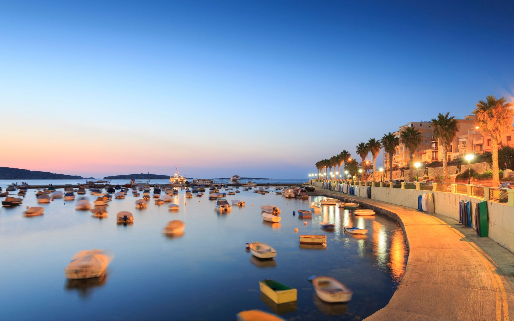 Kveldsstemning over havnepromenaden med småbåter i St. Pauls Bay på Malta