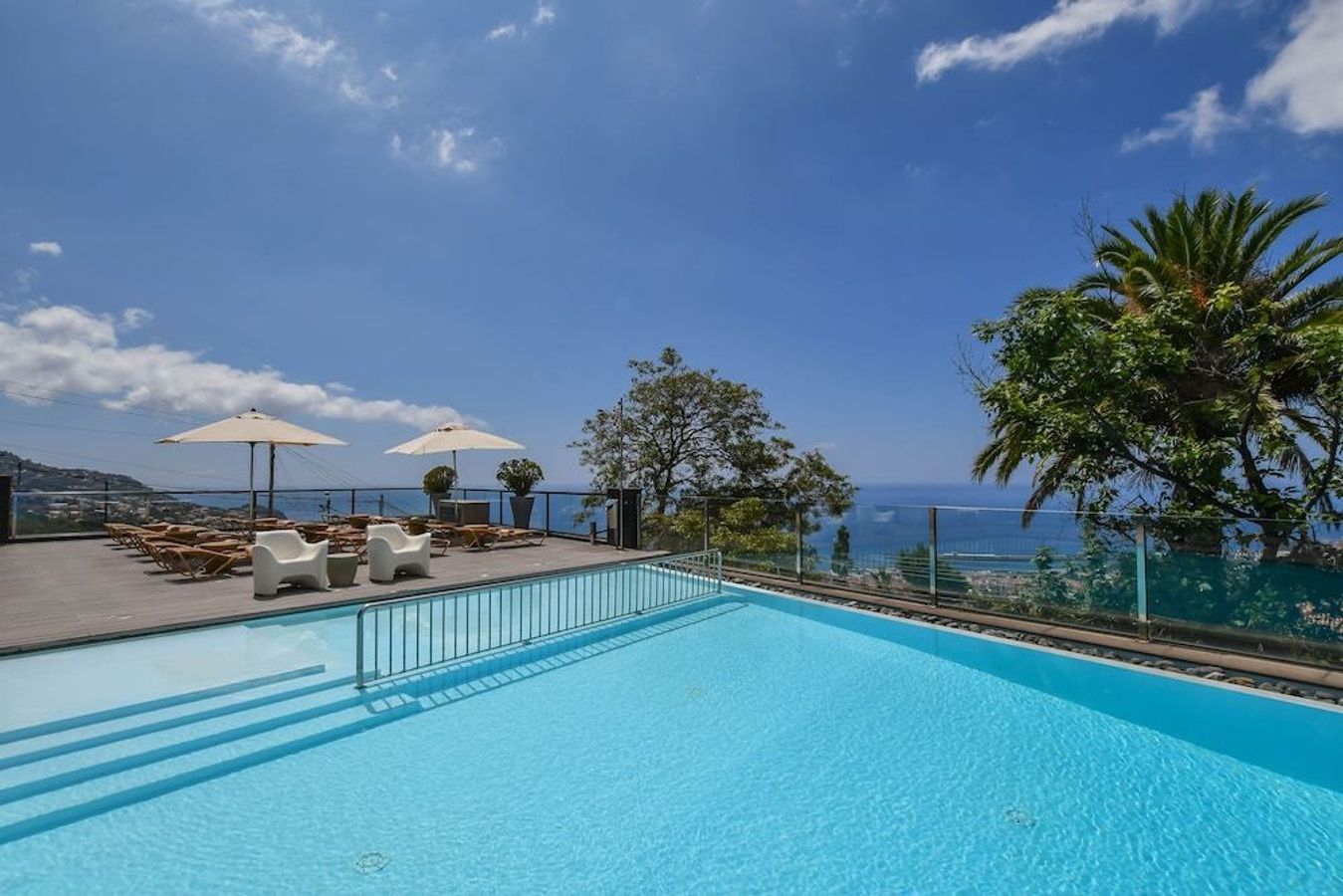Här visas utsikten från hörnet vid simbassängen på hotellet Quinta Mirabela i Funchal. Terrassen är utrustad med bekväma solstolar och parasoller.