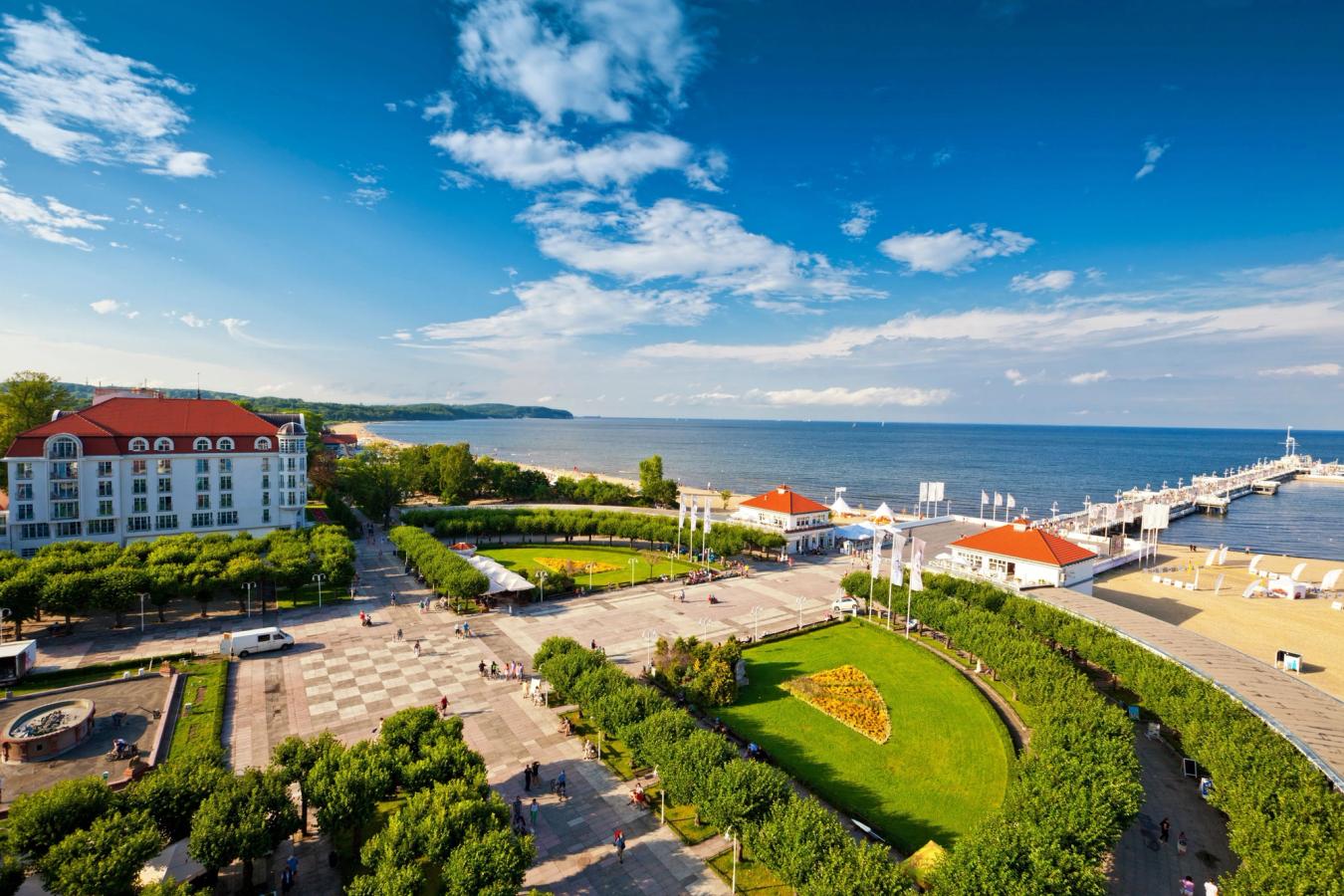 Bildet viser strand og strandpromenaden ved starten av "trebrygga" Molo w Sopocie, som Sopot i Polen er veldig kjent for