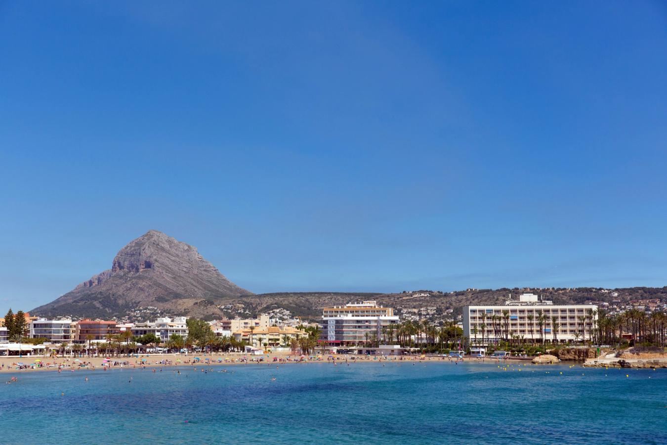 Huvudstranden i Javea, Playa del Arenal, en dag med molnfri blå himmel och Montgo-berget i bakgrunden