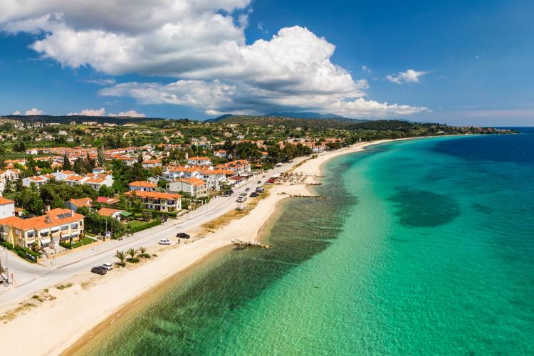 Panoramaudsigt over den langstrakte strand og det krystalklare hav i Nikiti i Halkidiki i Grækenland