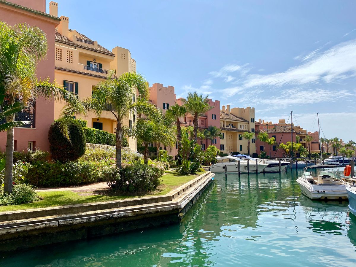 Billedet viser noget af marinaen i Sotogrande med både og huse og palmer i baggrunden. 