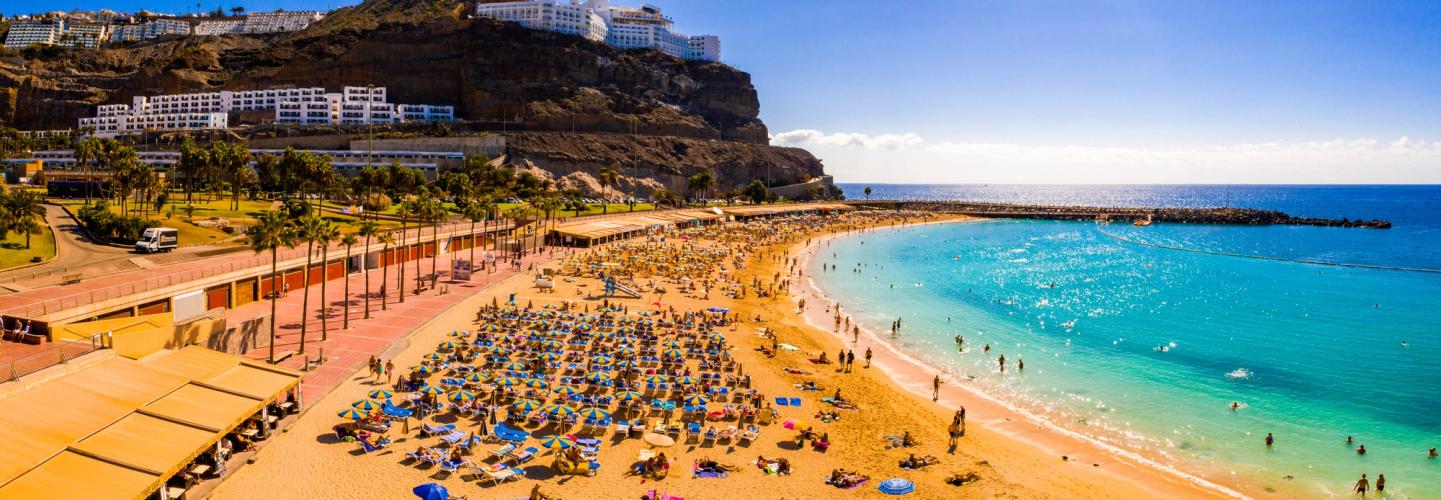 Utsikt over en lang, deilig sandstrand på Gran Canaria