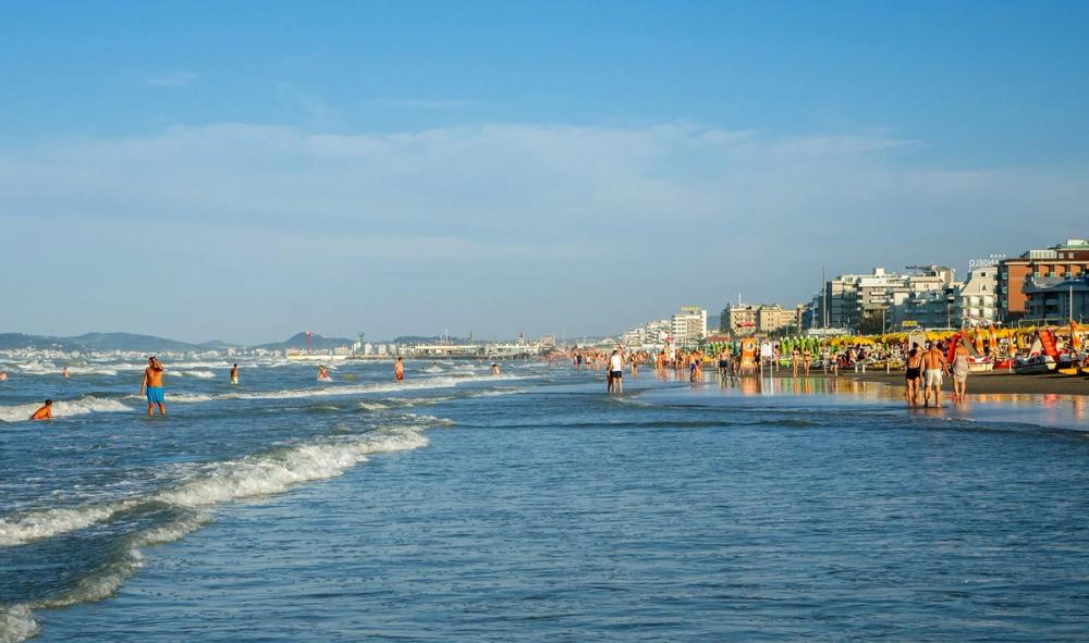 Utsikt over stranden i Riccione med mange mennesker som bader og soler seg, Italia