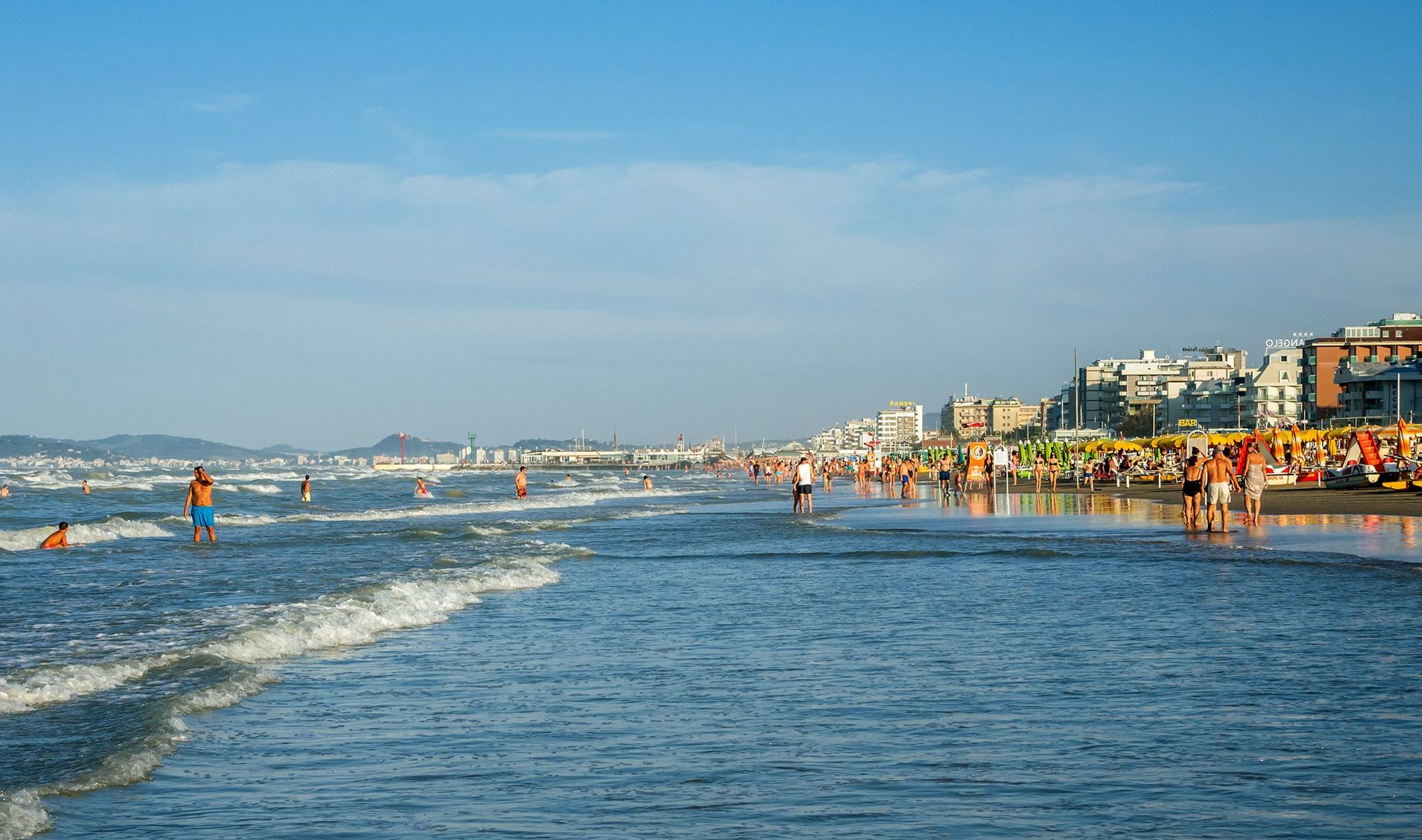 Utsikt over stranden i Riccione med mange mennesker som bader og soler seg, Italia