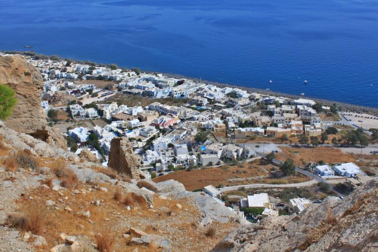 Panoramautsikt over Kamari på Santorini med den langstrakte mørke lavastranden