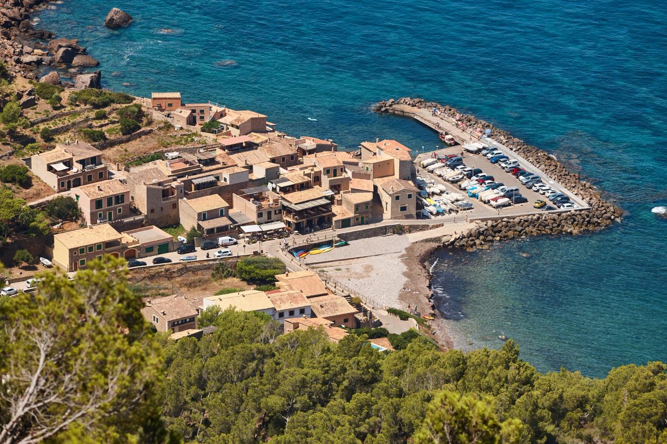 Utsikt over den lille havnen og stranden i Puerto de Valldemossa på Mallorca