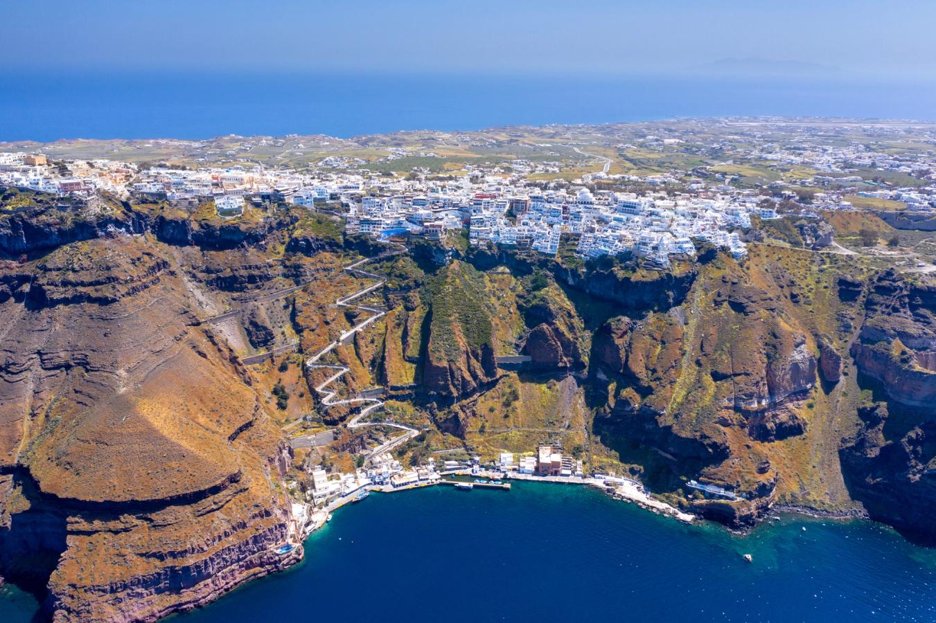 Panoramautsikt over byen Fira, vulkanområdet og den bratte svingete veien ned til cruisehavnen på Santorini