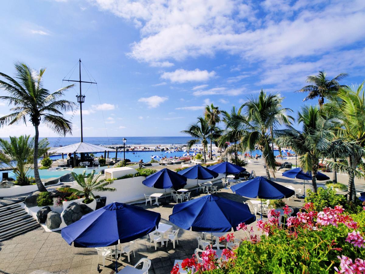 Utsikt over de store havbassengene med palmer og solstoler i Puerto de la Cruz på Tenerife