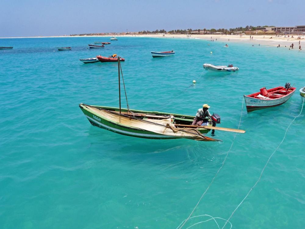Små, lokale fiskebåter på det azurblå havet ved stranden i Santa Maria på Kapp Verde