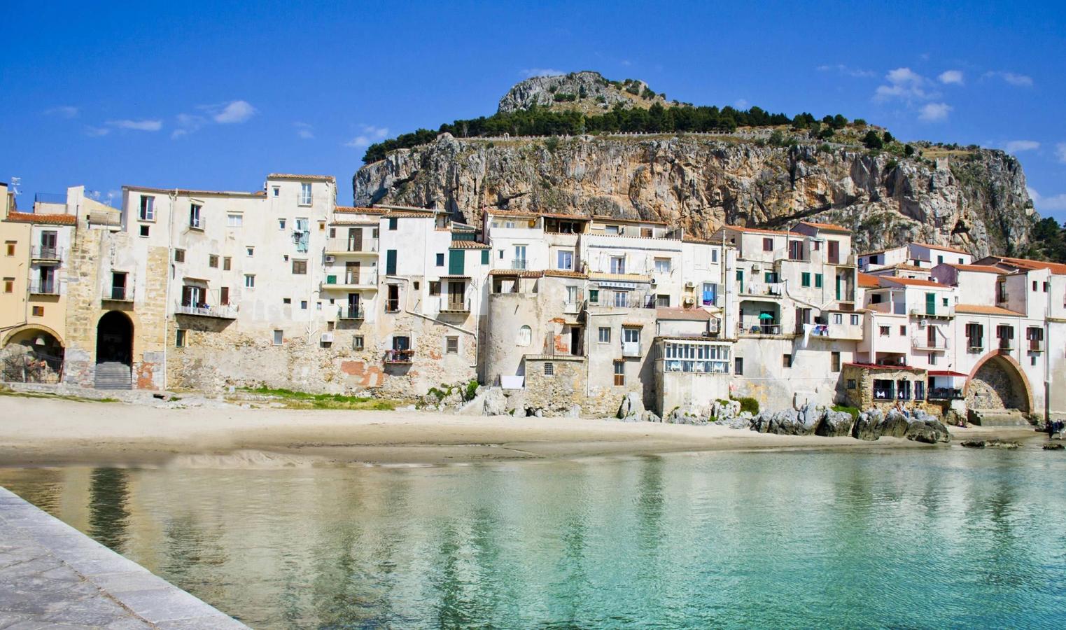 Den majestætiske klippe La Rocca tårner sig op over Cefalu på Sicilien