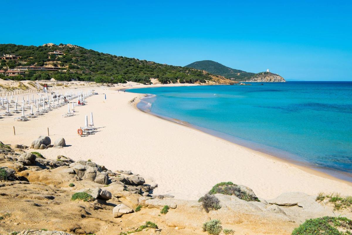 En långsträckt strand med kristallklart medelhavsvatten på ön Sardinien i Italien