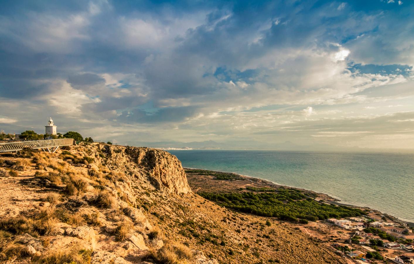 Fyrtårnet Faro de Santa Pola står midt i det klippefylte landskapet. Havet strekker seg ut i horisonten.