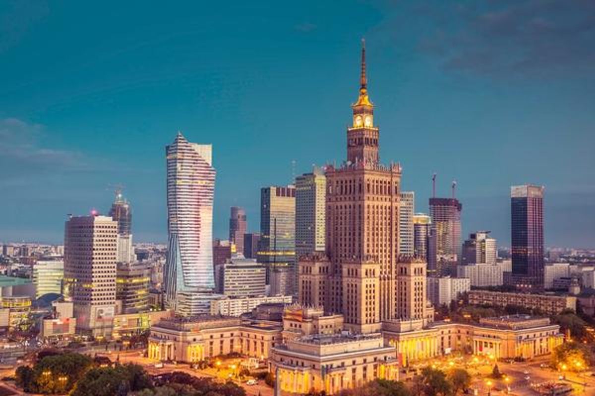 Bilden visar flera skyskrapor i staden Warszawa. I mitten av bilden syns Palace of Science and Culture, som är från sovjettiden och präglas av monumental arkitektur.