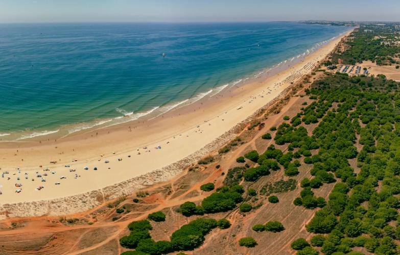 Vakker strand i Olhos de Água med klart blått hav og naturskjønn kystlinje som strekker seg fra Albufeira til Vilamoura, Algarve, Portugal