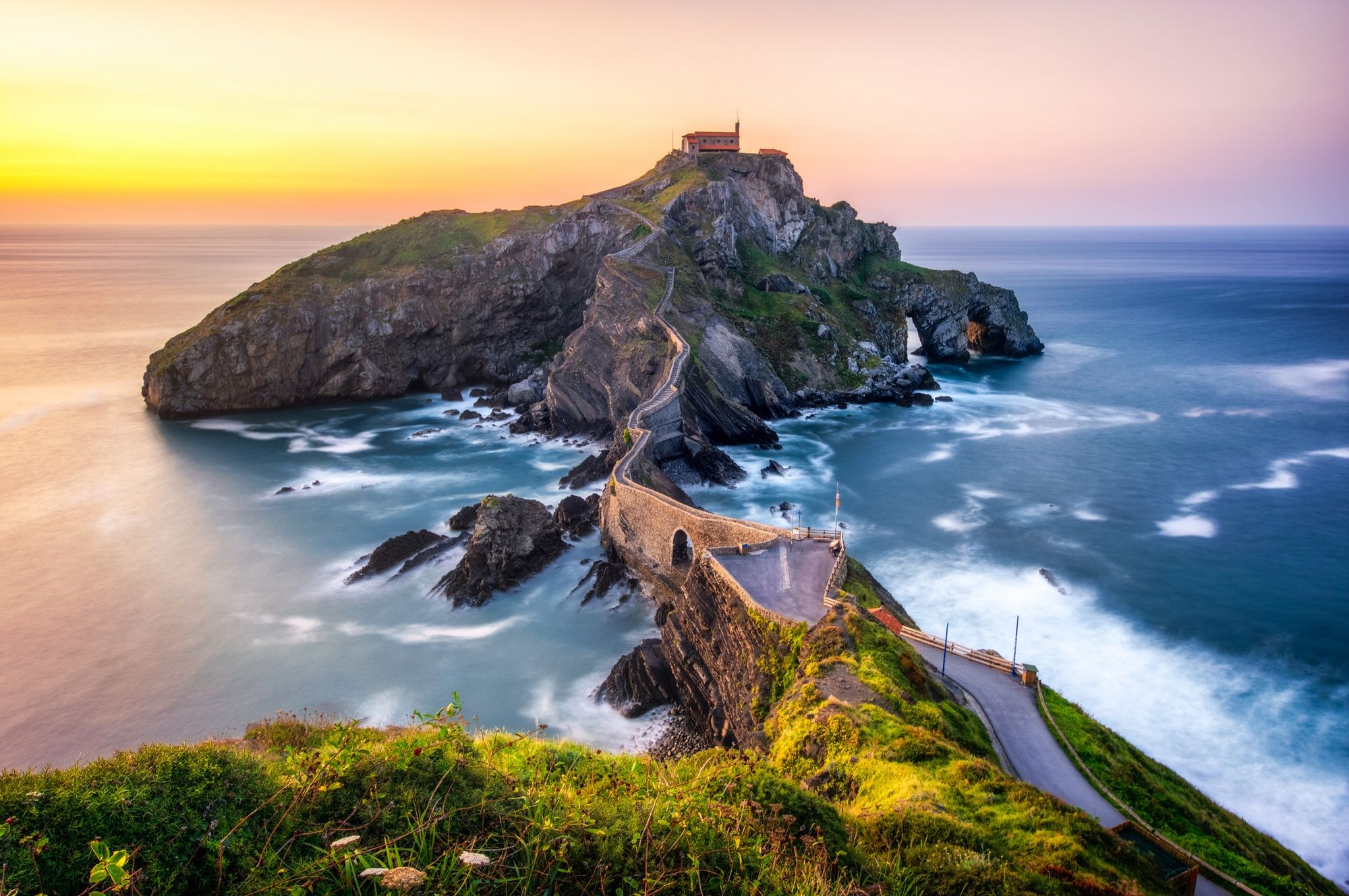 I Baskerland finner du øya Gaztelugatxe. En grønnkledd klippeøy i det mørkeblå Atlanterhavet. En smal, slynget steinbro forbinder øya med fastlandet.