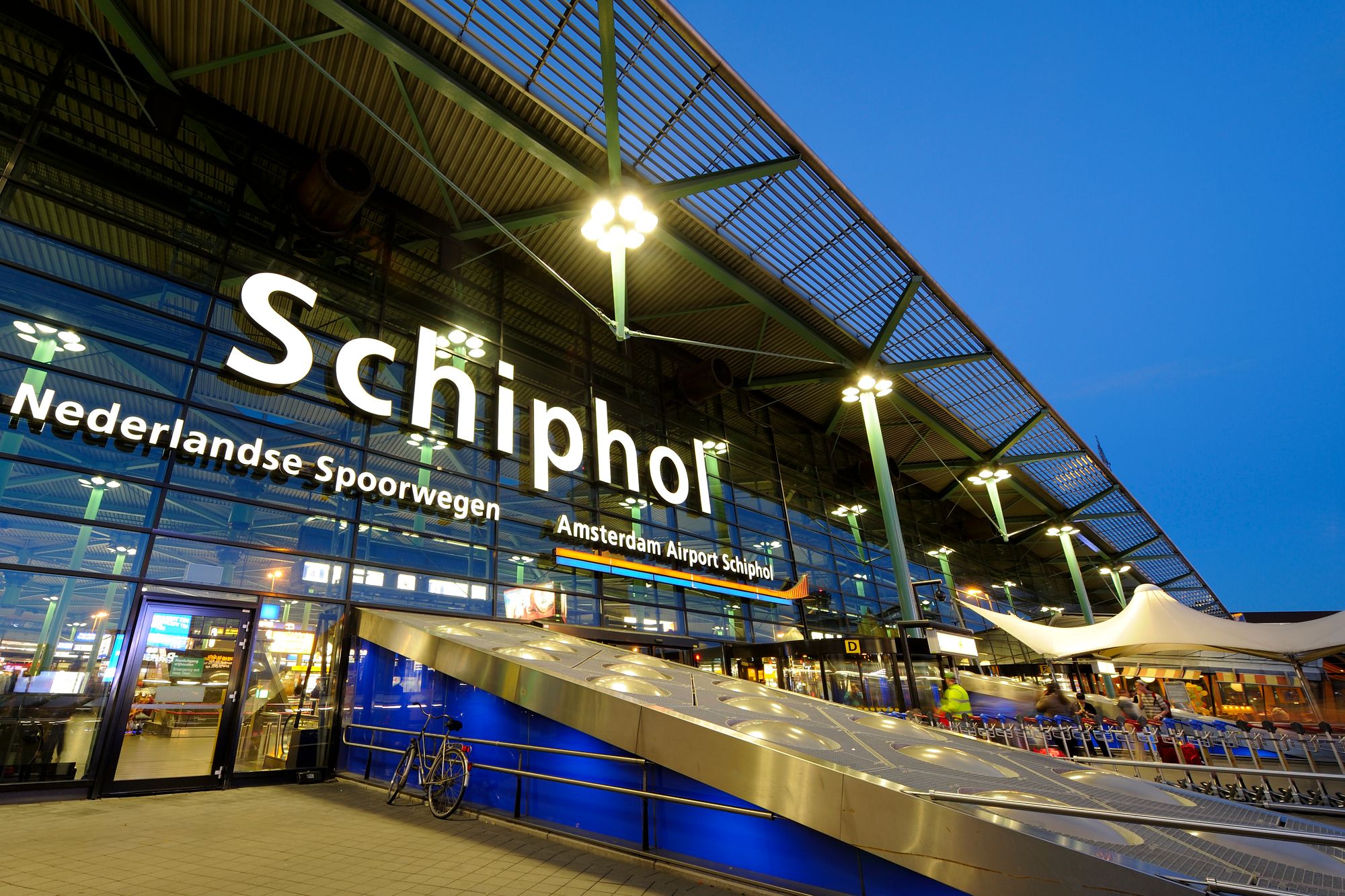 Inngangspartiet for Schiphol Flyplass med stor glassfasade og lyssetting