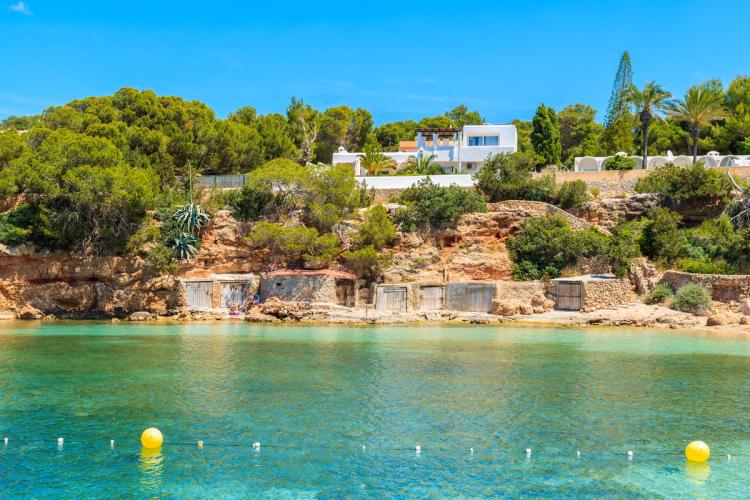 Turkistgrønt vann inn mot et frodig landskap i Sant Antoni de Portmany på Ibiza