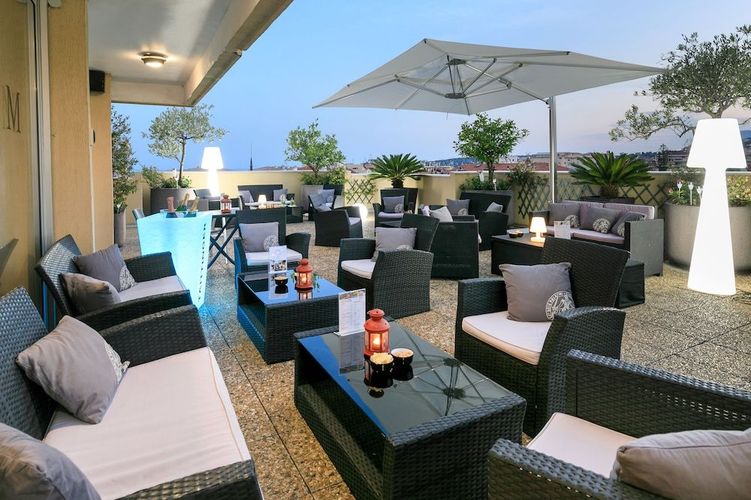 Nyt en rolig stund og en god drink på Mediterranee Hotels solterrasse i Menton, Frankrike.