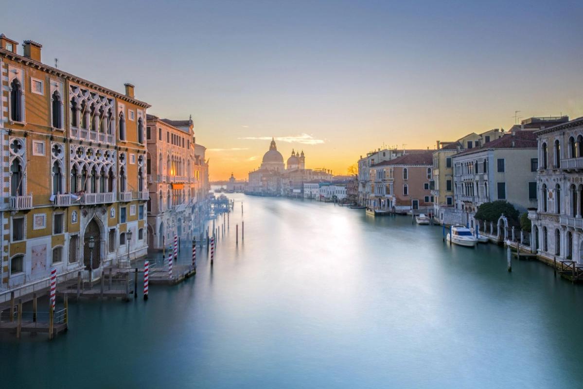 Bilden visar en lugn kväll på Canal Grande i Venedig, Italien