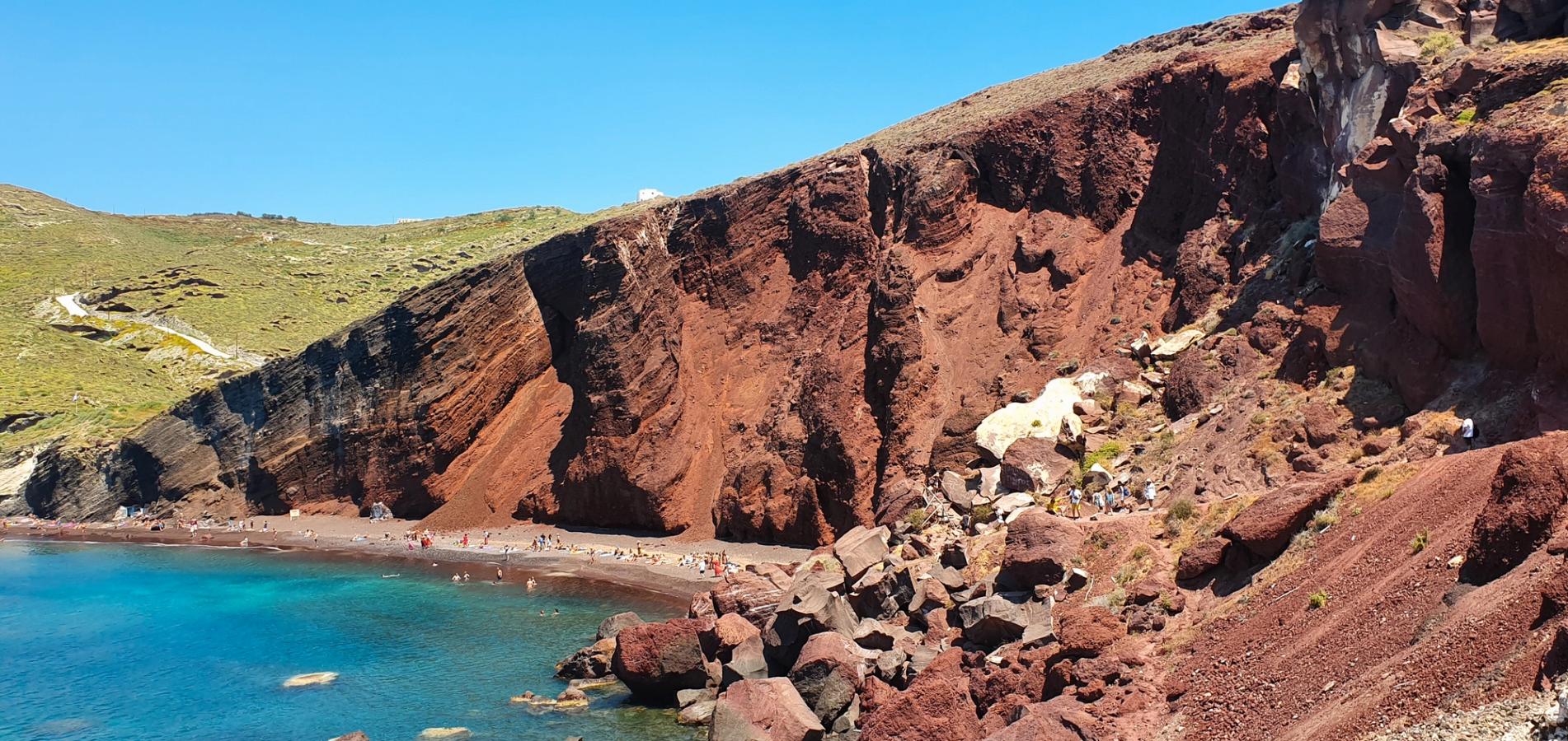 Utsikt over den spektakulære stranden Red Beach på Santorini med rød sand og høye røde klipper